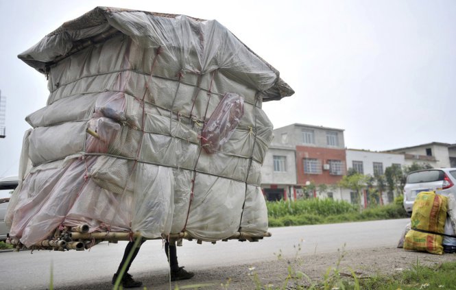 Nhà di động được làm từ tre và bao nilông của công nhân Liu Lingchao, 38 tuổi, tại khu tự trị Quảng Tây (Trung Quốc). Mỗi ngày ông “mang” ngôi nhà nặng khoảng 20kg đi bộ gần 20km để gom rác bán phế liệu - (Ảnh: Reuters)